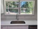 Bright kitchen with stainless steel sink and faucet, white countertop and large window at 2998 Se 140Th Ln, Summerfield, FL 34491
