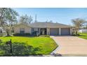 House exterior showcasing a two-car garage and well-manicured lawn at 3660 Se 54Th Ave, Ocala, FL 34480