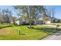 Landscaped front yard with a large tree and spacious driveway at 3660 Se 54Th Ave, Ocala, FL 34480