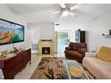 Living room with fireplace, comfy seating and large TV at 3805 Se 138Th Pl, Summerfield, FL 34491