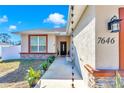 Inviting entryway with decorative rain chains, stone accents, and manicured landscaping at 7646 Sw 129Th Pl, Ocala, FL 34473