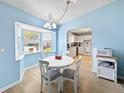 Bright dining area with white table and chairs, view into kitchen at 9395 Sw 97Th Ln # B, Ocala, FL 34481