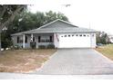 Charming one-story home with a white garage door and paver driveway at 9662 Sw 97Th Ln, Ocala, FL 34481