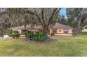 Single-story house with a tree-covered yard and a paved driveway at 10090 Sw 78Th Ct, Ocala, FL 34476