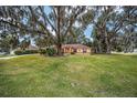 Ranch style home with large oak trees and lush lawn at 10090 Sw 78Th Ct, Ocala, FL 34476