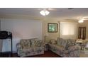 Living area with two floral sofas, vertical blinds, and hardwood floors at 10470 Sw 99Th Ave, Ocala, FL 34481