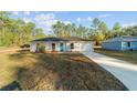 Newly built home, gray siding, teal door, and driveway at 2295 Sw 142Nd Court Rd, Ocala, FL 34481