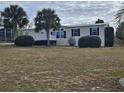 Single-story manufactured home with deck and landscaped yard at 8009 County Road 109D, Lady Lake, FL 32159