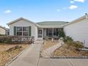 Landscaped front yard with a walkway leading to a screened porch at 9203 Se 179Th Lunsford Ln, The Villages, FL 32162