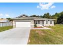 Welcoming single-story home with a two-car garage, a tidy front yard, and freshly painted exterior at 10871 Sw 62Nd Avenue Rd, Ocala, FL 34476
