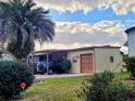 Charming single-story home featuring an attached carport, garage, and well-maintained lawn under a partly cloudy sky at 1628 Bay Meadows Ln, The Villages, FL 32159