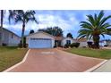 Single-story house with a two-car garage and nicely landscaped front yard at 17096 Se 96Th Chapelwood Cir, The Villages, FL 32162