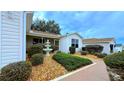 Inviting front entrance with fountain and nicely manicured landscaping at 17096 Se 96Th Chapelwood Cir, The Villages, FL 32162