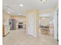 Open kitchen with stainless steel appliances and tile flooring, connected to dining area at 17163 Se 76Th Boxbury Ct, The Villages, FL 32162