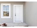 White front door with gray siding and a single window at 281 Marion Oaks Crse, Ocala, FL 34473