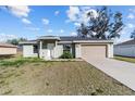 Newly constructed house with a light green exterior and a tan garage door at 4069 Sw 130Th Pl, Ocala, FL 34473