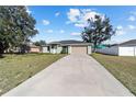 Charming single-story home with a well-maintained lawn, a long driveway, and an attached two-car garage at 4069 Sw 130Th Pl, Ocala, FL 34473