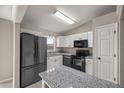 Modern kitchen with granite countertops and black appliances at 4677 Sw 166Th Loop, Ocala, FL 34473