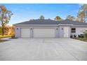 Three-car garage with light gray exterior and off-white doors at 4892 Nw 101St Street Rd, Ocala, FL 34482