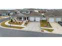 Two-story home with a front porch, two-car garage, and landscaped yard; aerial view at 6115 Sw 74Th Ct, Ocala, FL 34474