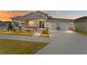 Two-story house with a front porch, two-car garage, and landscaped yard at dusk at 6115 Sw 74Th Ct, Ocala, FL 34474