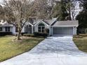 Single-story house with grey siding, landscaped lawn, and driveway at 10814 Sw 83Rd Ave, Ocala, FL 34481