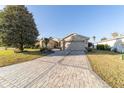 Well-maintained house with a large paver driveway and mature trees at 16182 Sw 14Th Ave Rd, Ocala, FL 34473