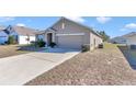 Front view of a single-story house with a garage and driveway at 27 Hickory Course Ln, Ocala, FL 34472