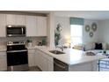 Modern kitchen with white cabinetry, stainless steel appliances, and island seating at 3290 Bertram Rd, Wildwood, FL 34785