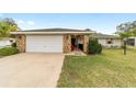 Single story home with a 2-car garage, stone accents, and a well-maintained lawn at 5041 County Road 114, Wildwood, FL 34785