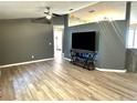 Spacious living room with gray walls, wood-look floors, and a large TV at 6082 Sw 104Th St, Ocala, FL 34476