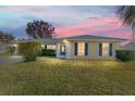 House exterior at dusk with green roof and well-maintained lawn at 73 Bahia Trace Crse, Ocala, FL 34472