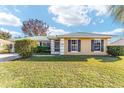 Tan house with green roof, well-maintained lawn at 73 Bahia Trace Crse, Ocala, FL 34472