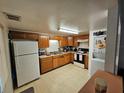 Galley kitchen with wood cabinets, white appliances, and washer/dryer at 8208 Fairways Cir # B101, Ocala, FL 34472