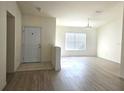 Living area with wood-look floors, a half wall, and a view of the front door at 8697 Se 136Th Ln, Summerfield, FL 34491