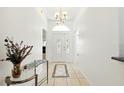 Bright foyer features tiled floors, decorative vases, and a chandelier, creating an elegant entrance at 8990 Se 178Th Muirfield Pl, The Villages, FL 32162