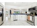Modern kitchen with stainless steel appliances, white cabinetry, and ample counter space for cooking at 8990 Se 178Th Muirfield Pl, The Villages, FL 32162