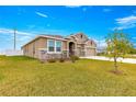 House with stone accents, two-car garage and a manicured lawn at 9181 Sw 49Th Ct, Ocala, FL 34476