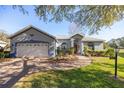 Charming one-story home showcasing a red front door and brick walkway at 9554 Sw 93Rd Loop, Ocala, FL 34481