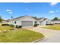 Single-story home with attached garage, mature landscaping, and paved driveway at 9836 Se 175Th Pl, Summerfield, FL 34491