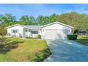 Charming single-story home featuring a well-maintained lawn, white siding, and an attached two-car garage at 10882 Sw 62Nd Ave, Ocala, FL 34476