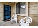 Small front porch with two white plastic chairs at 10918 Se 50 Ave, Belleview, FL 34420