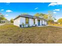 Modern home with white exterior, gray accents, and landscaped yard at 14108 Se 42Nd Ter, Summerfield, FL 34491