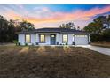 House exterior at sunset showcasing gray roof, white walls, and blue door at 14108 Se 42Nd Ter, Summerfield, FL 34491