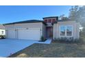 Inviting single-Gathering home showcasing a two-car garage, well-kept landscaping, and a welcoming front entrance at 19448 Sw 78Th Pl, Dunnellon, FL 34432