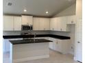 Modern kitchen featuring white cabinets, black countertops, and stainless steel appliances at 2154 Nw 23Rd Loop, Ocala, FL 34475