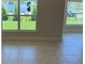 Bright living room with large windows offering a view of the green outdoors and tiled floor at 2154 Nw 23Rd Loop, Ocala, FL 34475
