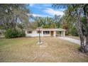 Beautiful single-story house with large front yard, attached carport and mature trees, with brick walkway at 2501 Nw 20Th St, Ocala, FL 34475