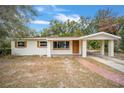 Charming single-story home featuring a brick walkway and attached carport surrounded by mature trees at 2501 Nw 20Th St, Ocala, FL 34475