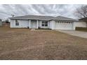 Front view of a single story house with a garage and yard at 28 Juniper Loop Ter, Ocala, FL 34480